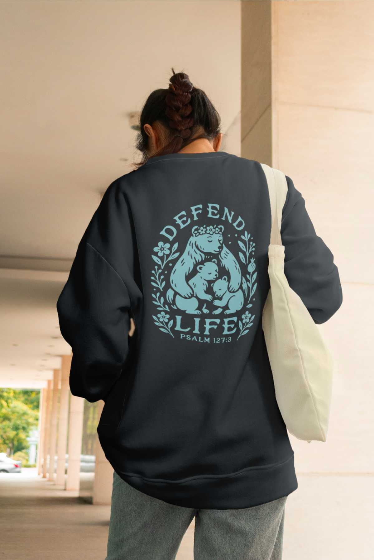 A woman wearing a pro-life sweatshirt that helps support those who protect the unborn